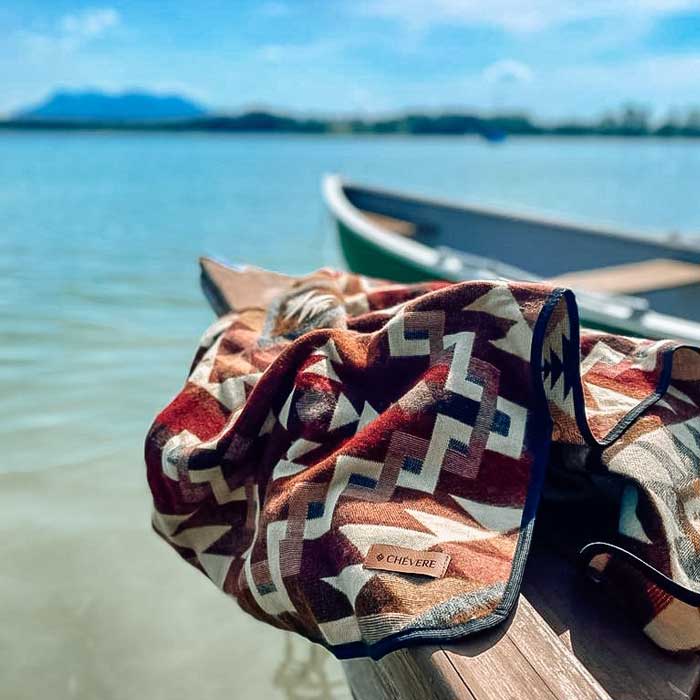 Chevere Picknickdecke im Bohostyle. Kuscheldecke in rotem Ethno-Muster.