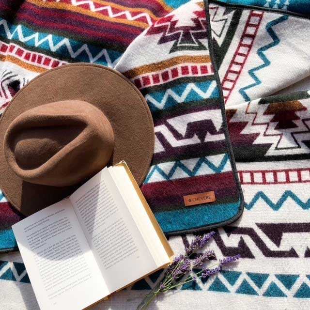 Chevere Bohemian-Decke mit tyischen Ethno-Mustern in Türkis.