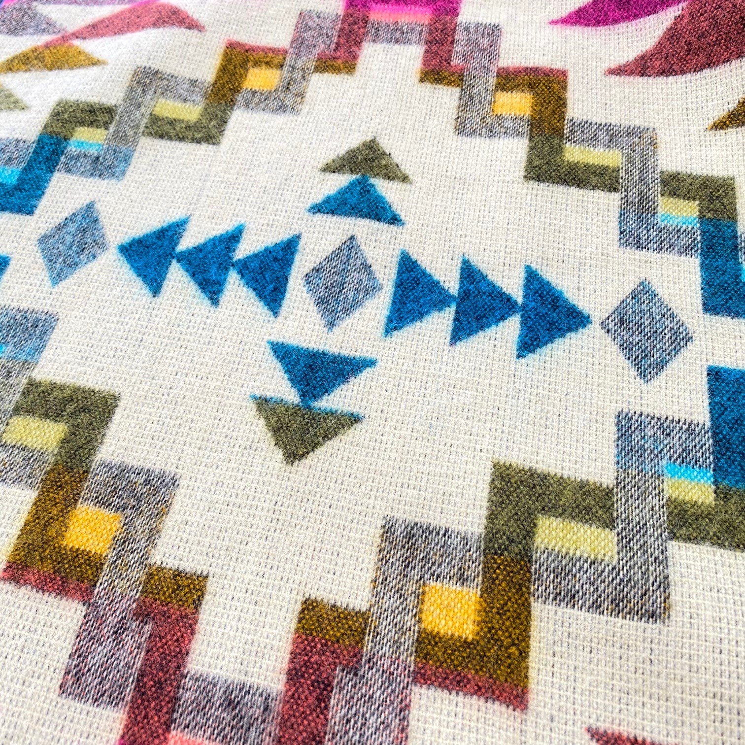 Chevere Kuscheldecke im Reiseformat - Nahaufnahme vom bunten Ethno-Muster.