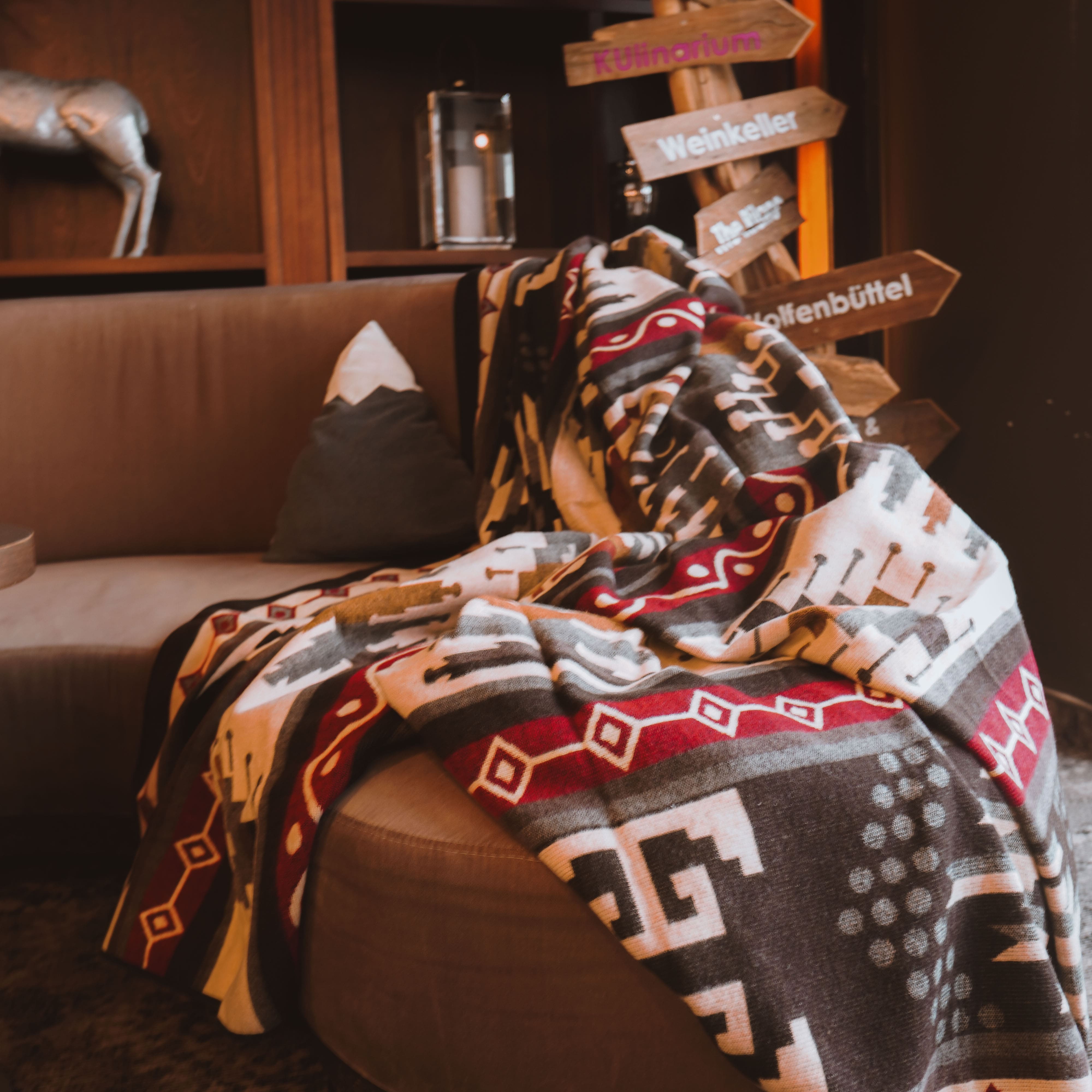 Chevere rote Kuscheldecke im Boho-Style auf dem Sofa im Wohnzimmer.